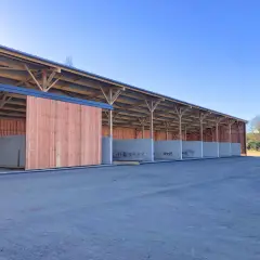 Structure en bois et béton pour construire une fumière. Les murs en béton sont déjà en place, prêts à recevoir le compost.