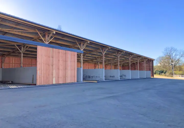 Structure en bois et béton pour construire une fumière. Les murs en béton sont déjà en place, prêts à recevoir le compost.