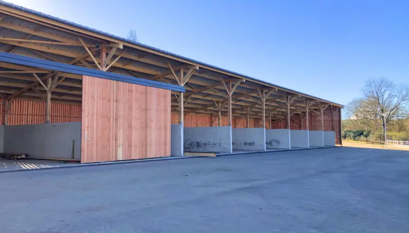 Structure en bois et béton pour construire une fumière. Les murs en béton sont déjà en place, prêts à recevoir le compost.