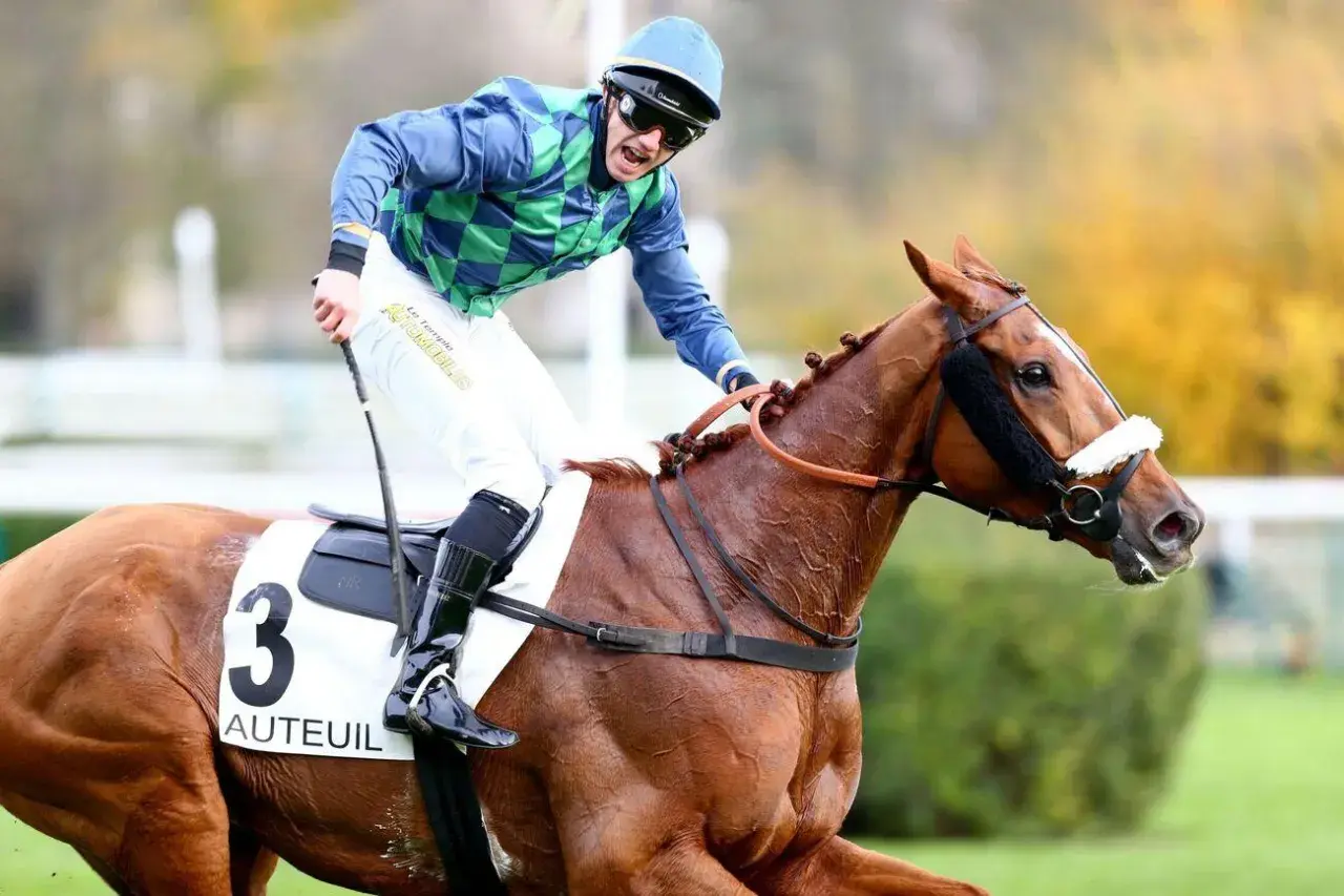 Un jockey en tenue bleue et verte, sur un cheval bai portant le numéro 3 "Auteuil", sprinte vers la victoire.
