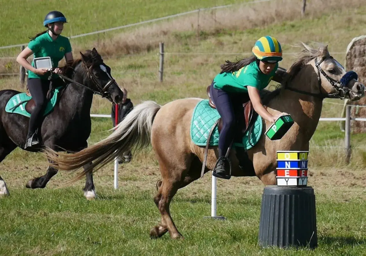 Deux jeunes cavali&egrave;res en action, prouvant que l'&eacute;quitation est un sport exigeant. Elles man&oelig;uvrent leurs poneys lors d'une &eacute;preuve.