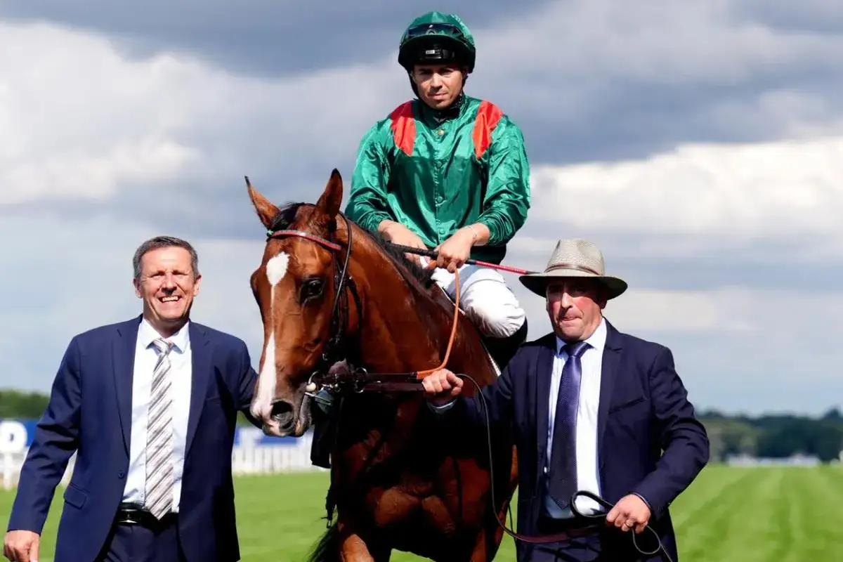 Un jockey sur un magnifique cheval pur-sang, accompagné de deux hommes en costume, sur une piste d'hippodrome.